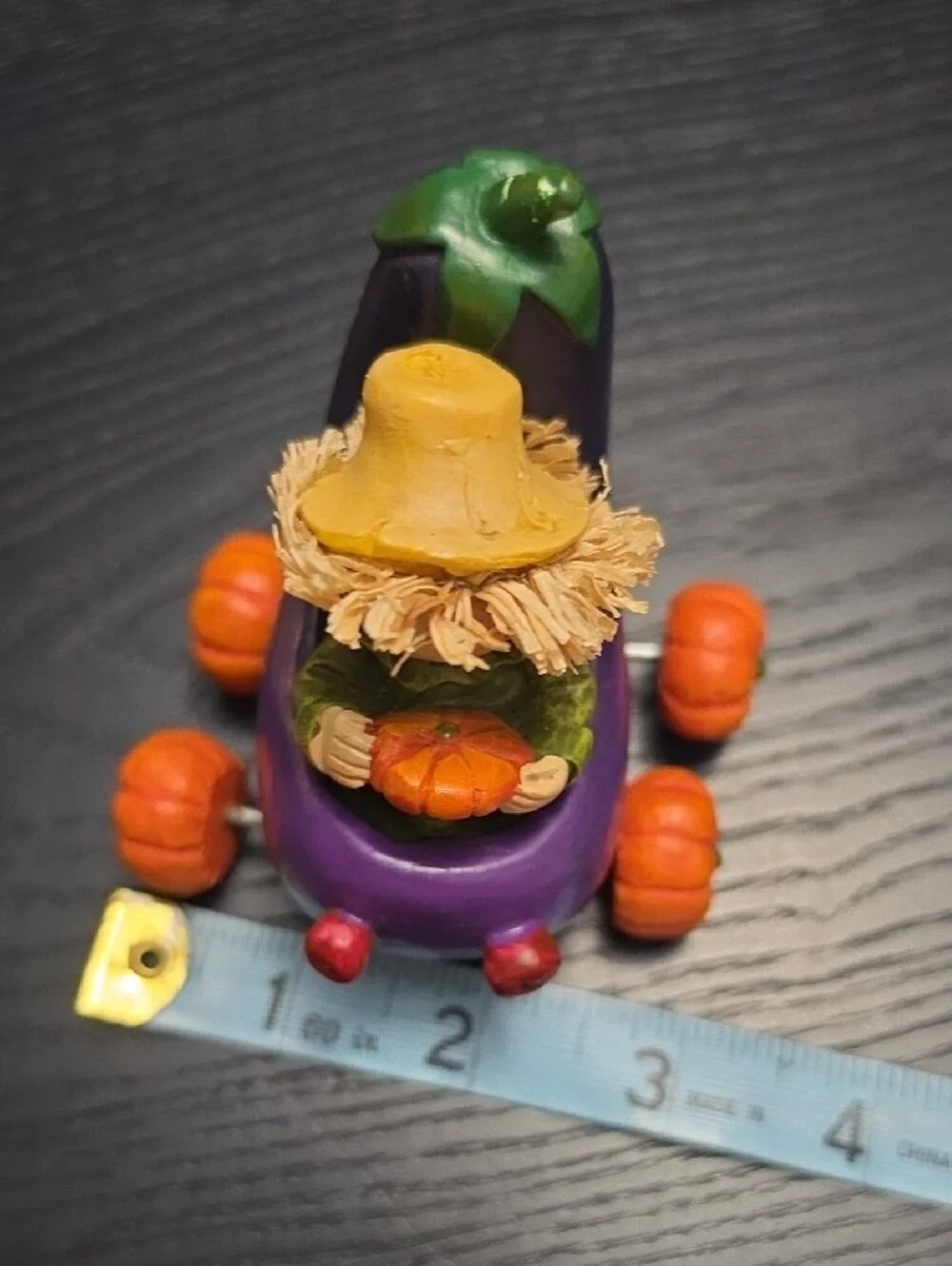 Autumn figurine of a scarecrow in a Eggplant cart